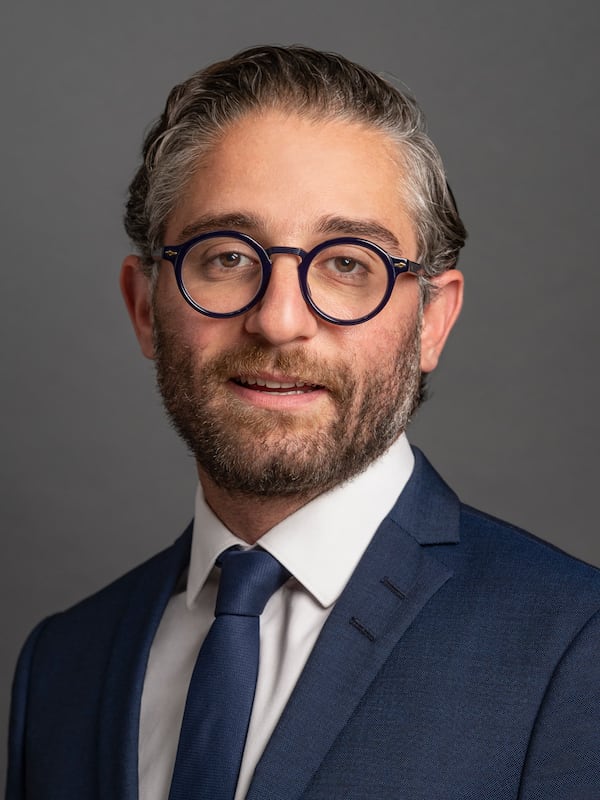 Headshot of a man wearing suit and glasses