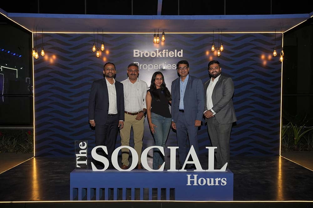 Group photo at Brookfield Properties' 'The Social Hours' networking event, featuring five professionally dressed attendees standing in front of a branded backdrop with modern lighting.
