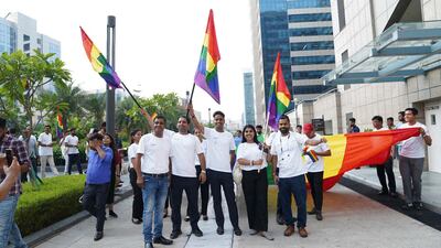 people in white tshirts holding pride flag