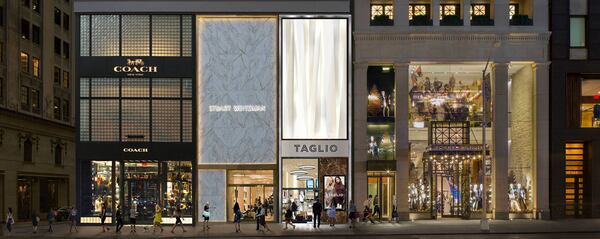 A line of shoppers on the sidewalk near Coach, Tommy Hilfiger, Stuart Weitzman, and Taglio.