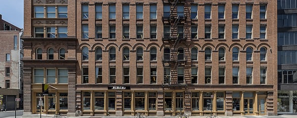 An exterior shot of a building. The building is made of intricately laid bricks and is several stori